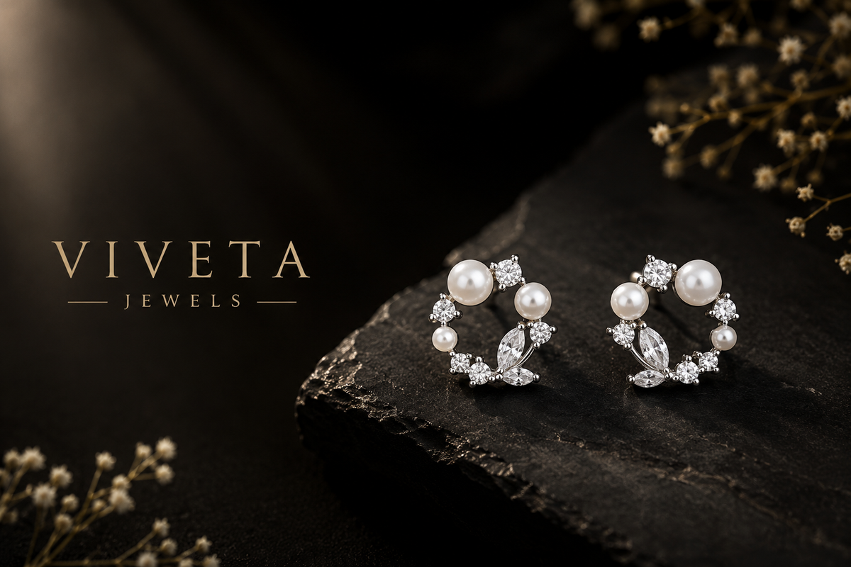 Pearl and crystal earrings on a dark stone surface with 'Viveta Jewels' branding.